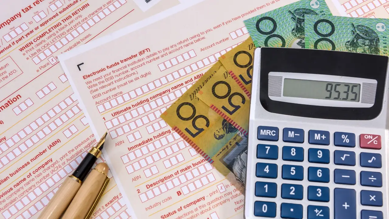 Australian tax form with pen and dollars and calculator